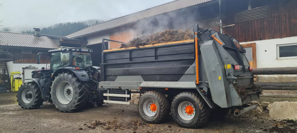 Traktor mit Mistanhänger - landwirtschaftliche Dienstleistung Traktor mit Mistanhänger - landwirtschaftliche Dienstleistung
